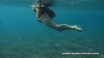 Julia is swimming underwater nude in the sea