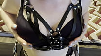 Mistress massages her big natural tits dressed in black bra and belt